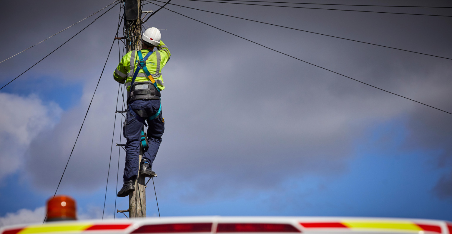 telecoms cis worker working on a telegraph pole